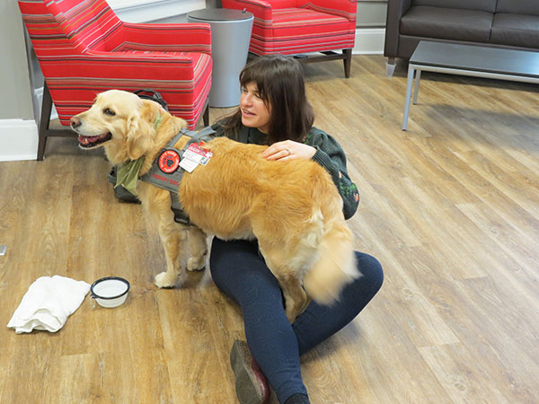 Dr. Kantarovich sits with the dog Mabel from Buckeye Paws