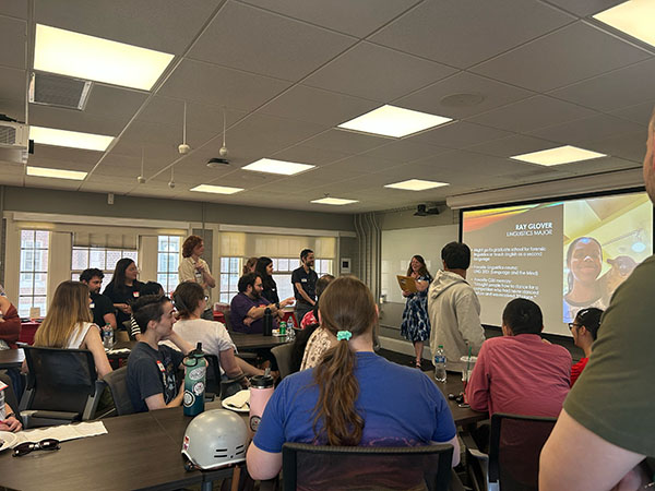 students and faculty eating and watching the slideshow