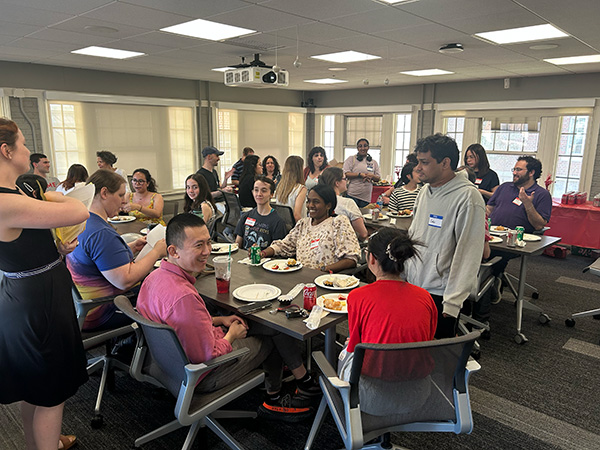 students and faculty eating and visiting at the party