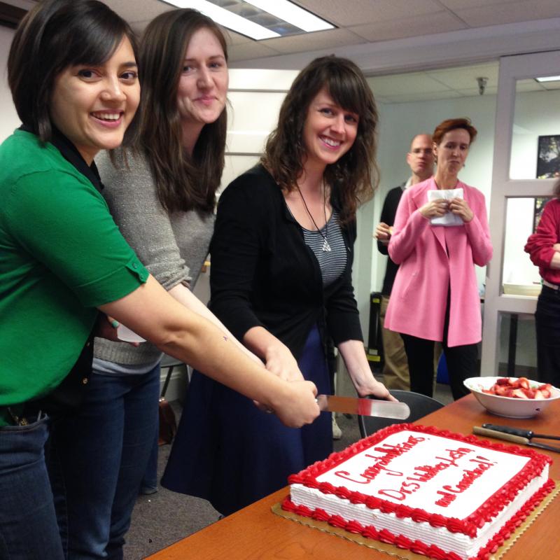 Spring 2014 PhD grads Marivic Lesho, Abby Walker and Katie Carmichael cut the cake