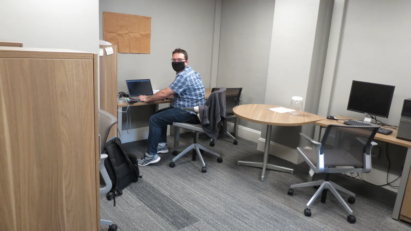 Student working alone in office with mask