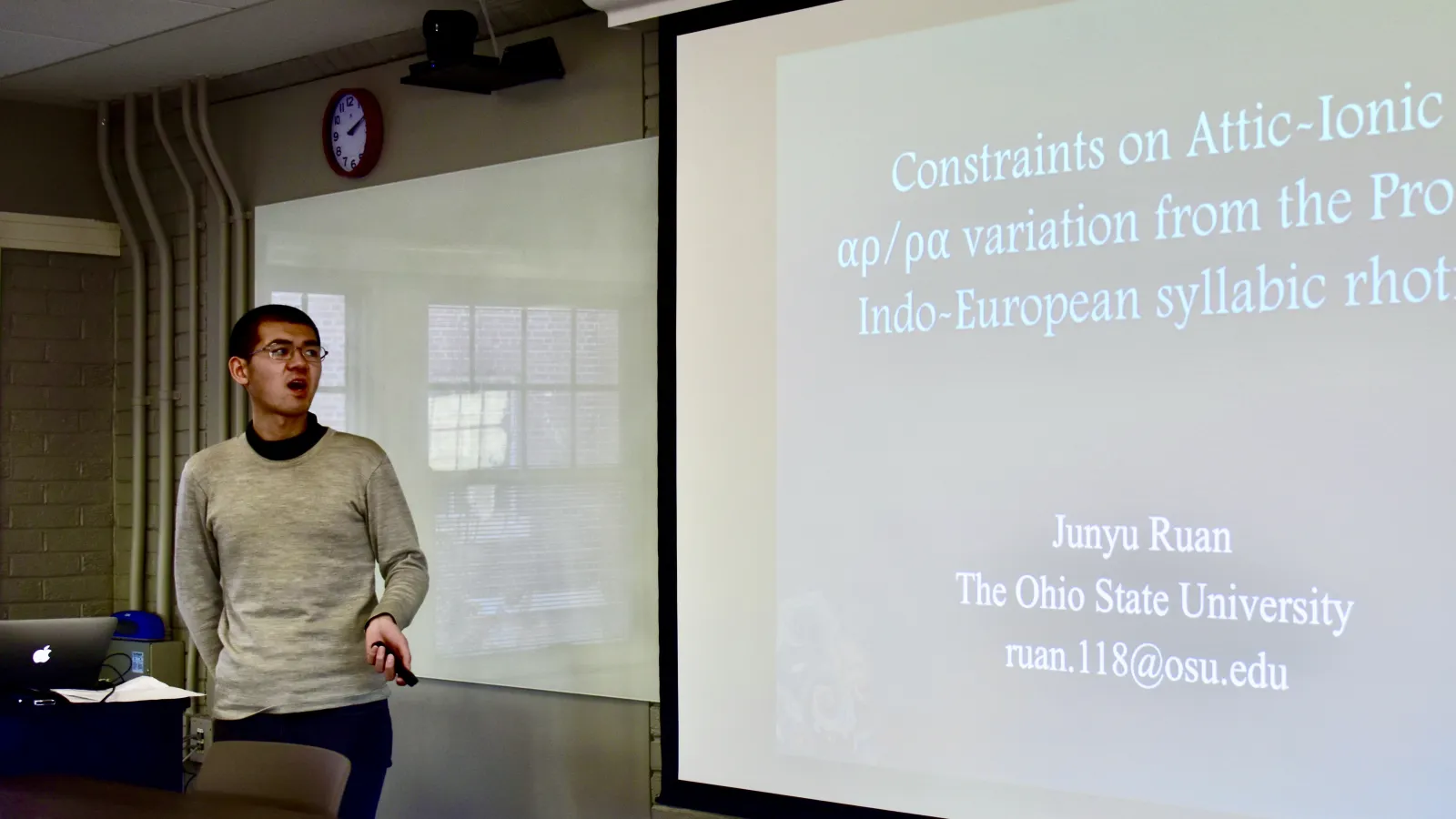 Junyu Ruan presenting a paper at a workshop.