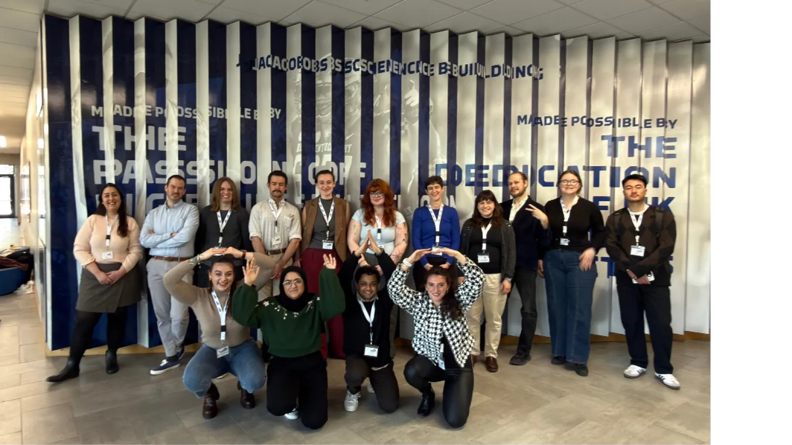group of linguists standing in front of a blue and white wall at the conference