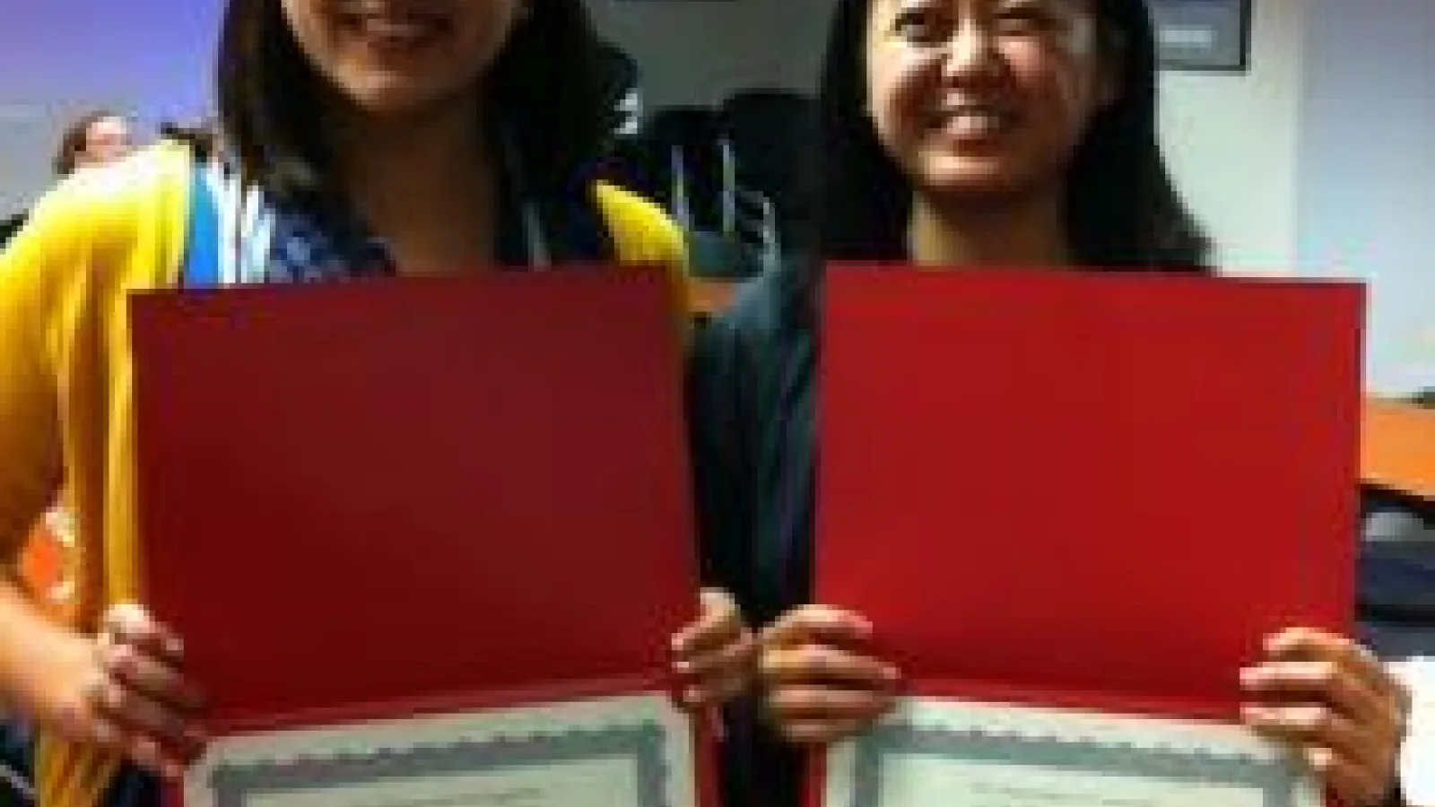 Marivic Lesho and Michelle Dionisio holding awards