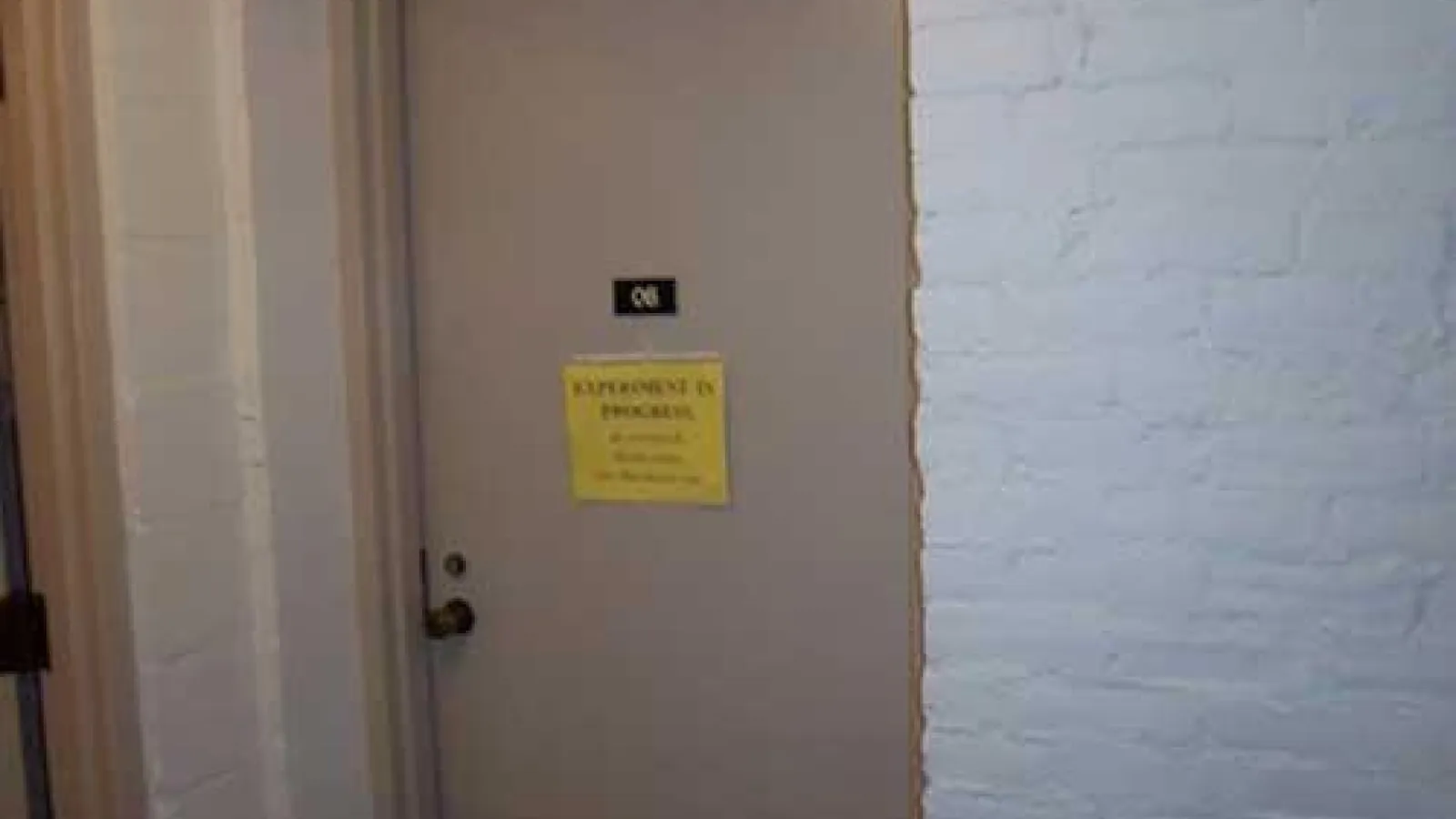 Sound booth door closed with a sign "Experiment in Progress" (slide 2 of 2)