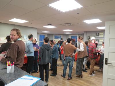 many people standing together and visiting and drinking hot chocolate