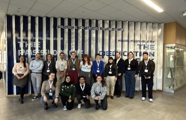 group of linguists standing in a row in front of a blue and white wall