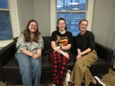 three people sitting together on a couch