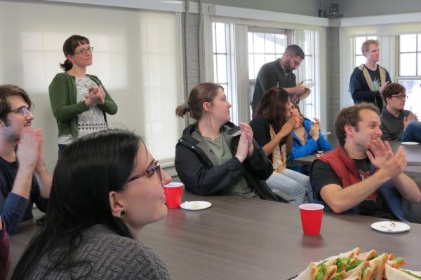 Linguistics faculty and students applauding at the 2019 end-of-year reception