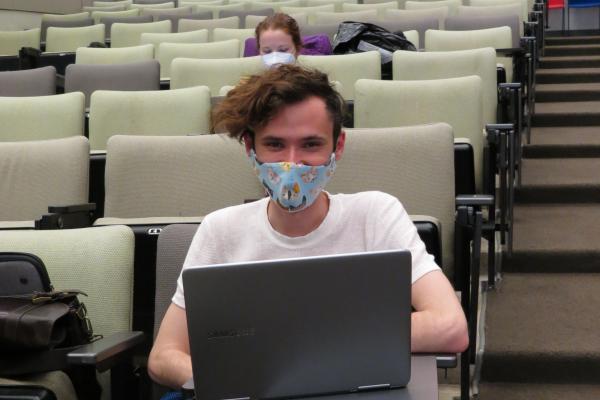 Picture of masked grad student in distanced classroom
