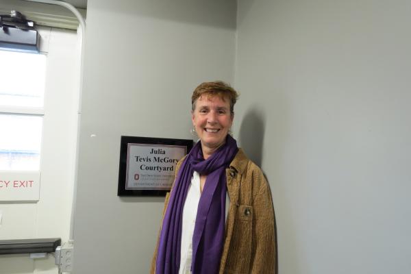 Julie McGory next to the sign for the courtyard