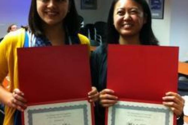 Marivic Lesho and Michelle Dionisio holding awards