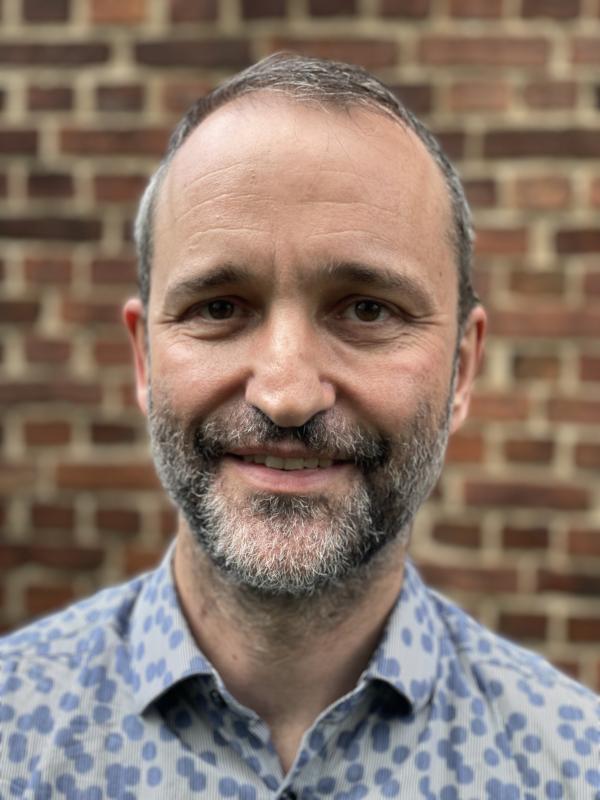 This picture shows a man in a blue shirt; he also has a beard, which is more permanent than the shirt.