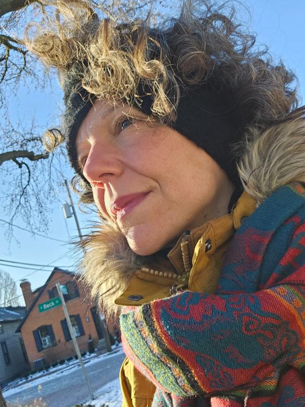 Laura in winter attire looking at the sun