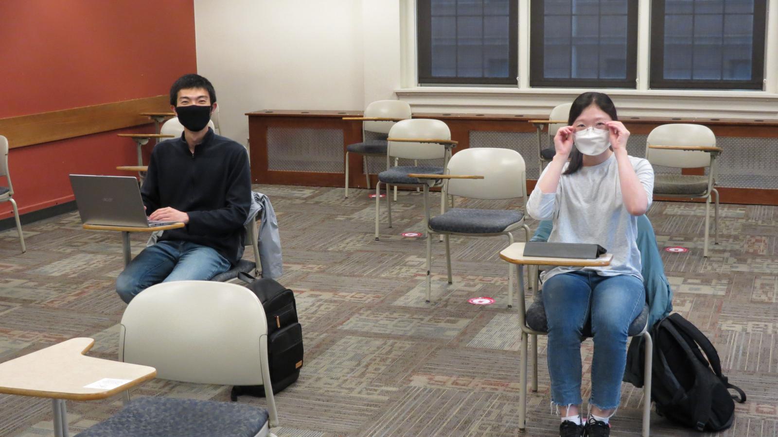 Two students, masked and distanced.