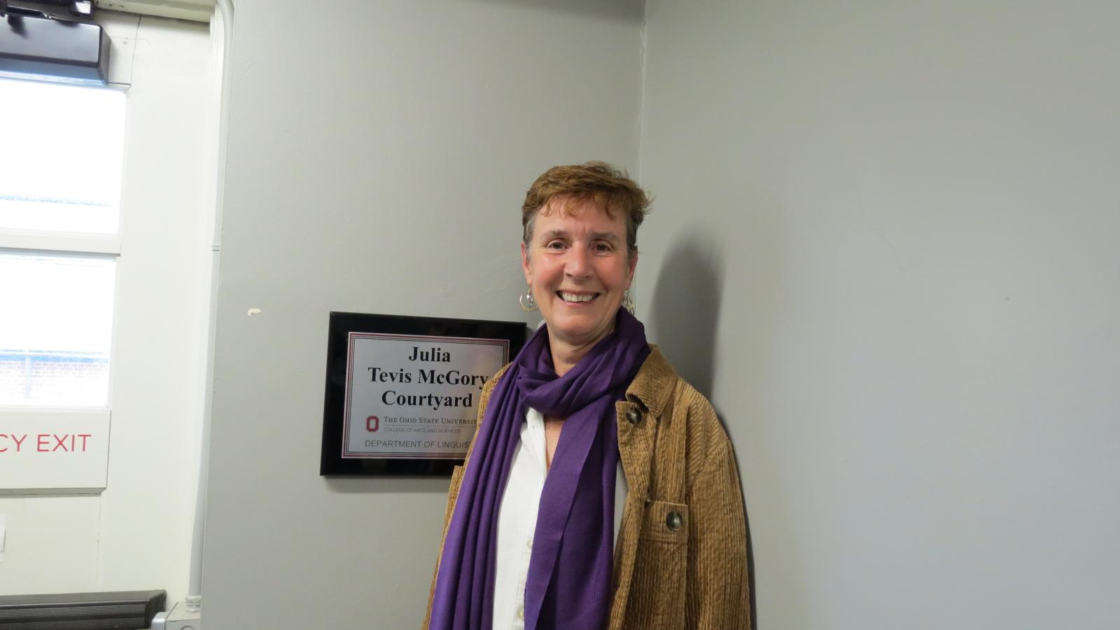 Julie McGory next to the sign for the courtyard