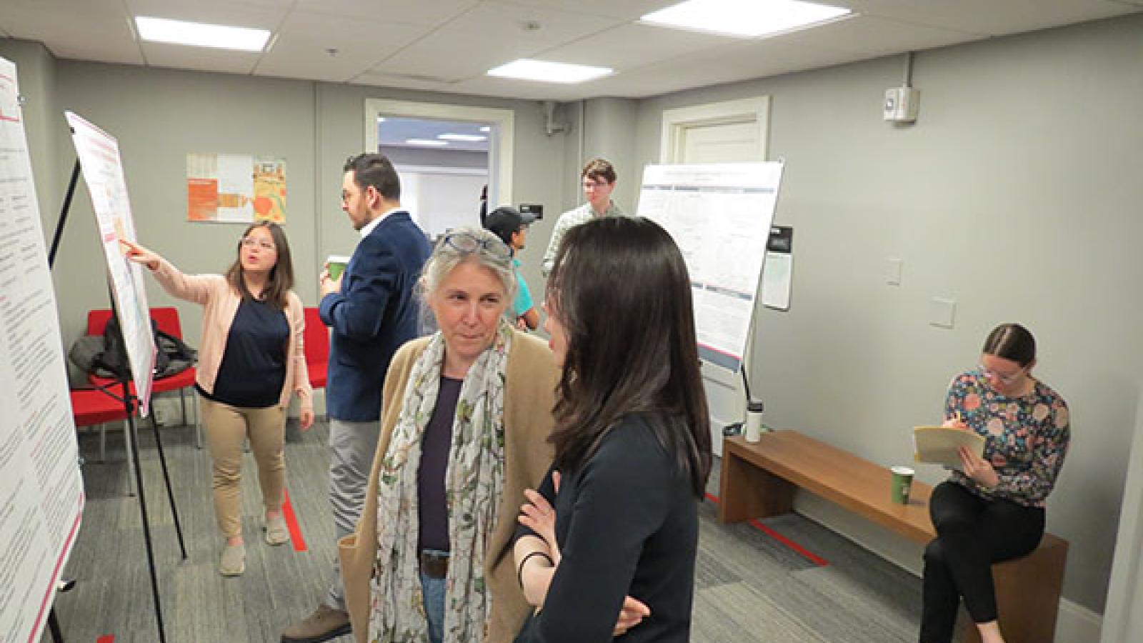 various students presenting their posters to guests in the Oxley foyer